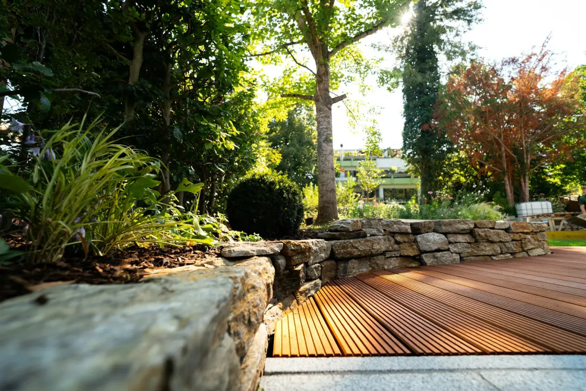 Dry-stone retaining wall holding a planted bank beside a timber deck
