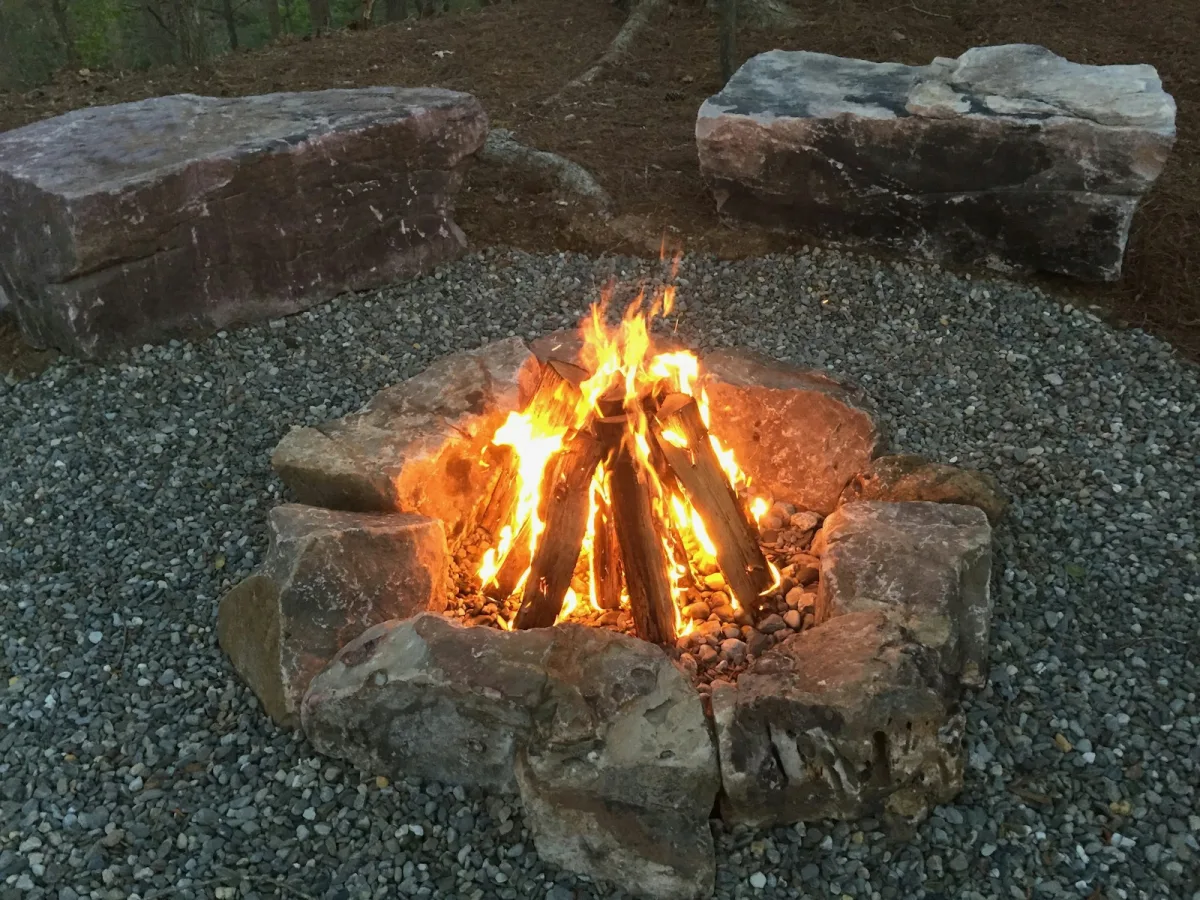 Fire feature ringed with boulders on a gravel terrace